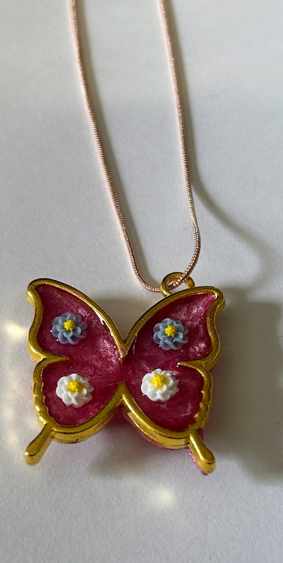 Necklace with pink butterfly gold tone frame with blue and white flowers on n 17" rose gold snake chain